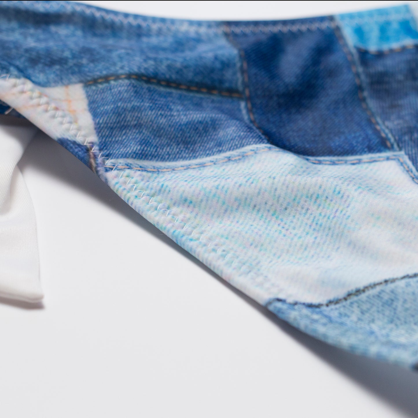 Kék denim hatású női bikini alsó, részletfotó a varrásról és az anyag mintázatáról.