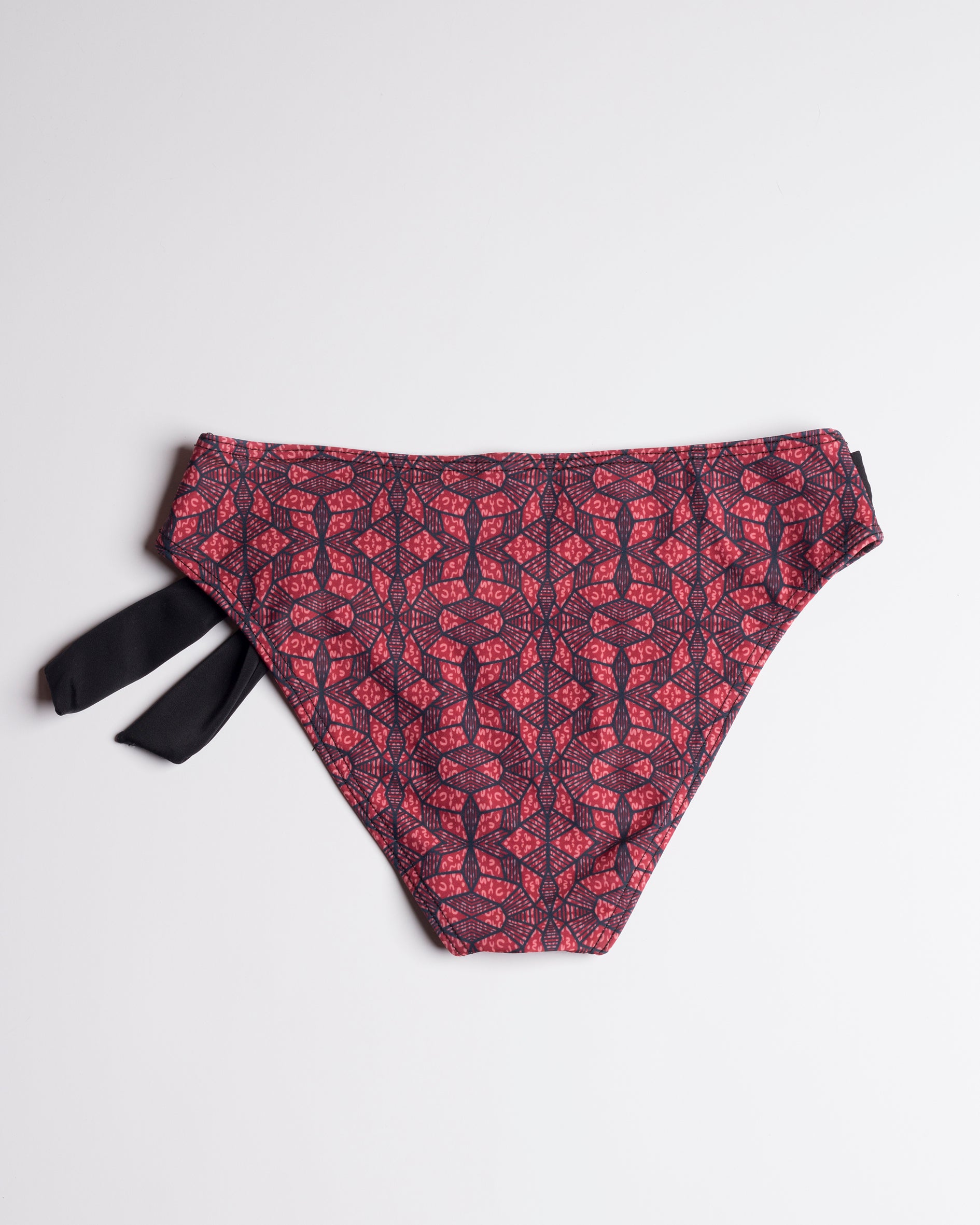 Navalang - Vörös-fekete absztrakt mintás, fekete díszmegkötős klasszikus teli bikini alsó, hátulról fehér háttéren