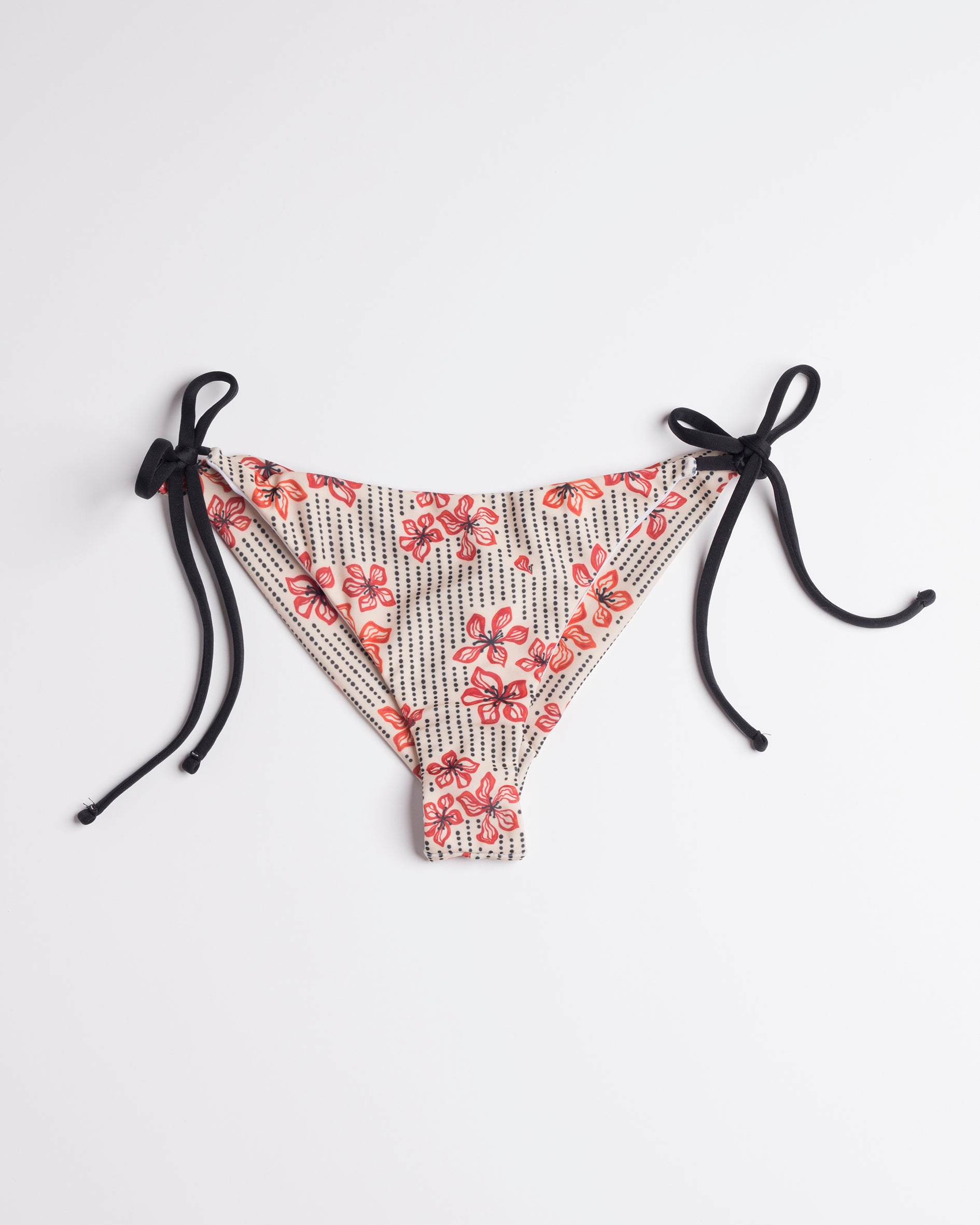Japán virágmintás brazil bikini alsó, fekete oldalsó megkötőkkel, fehér háttéren.