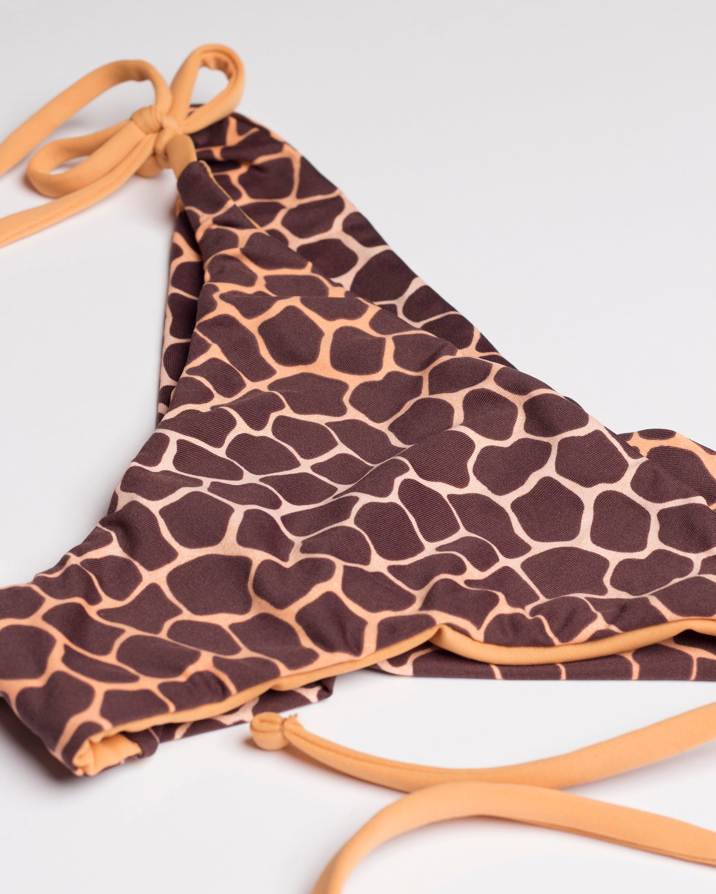 Zsiráfmintás brazil bikini alsó oldalról és ferdén fotózva, fehér háttéren.