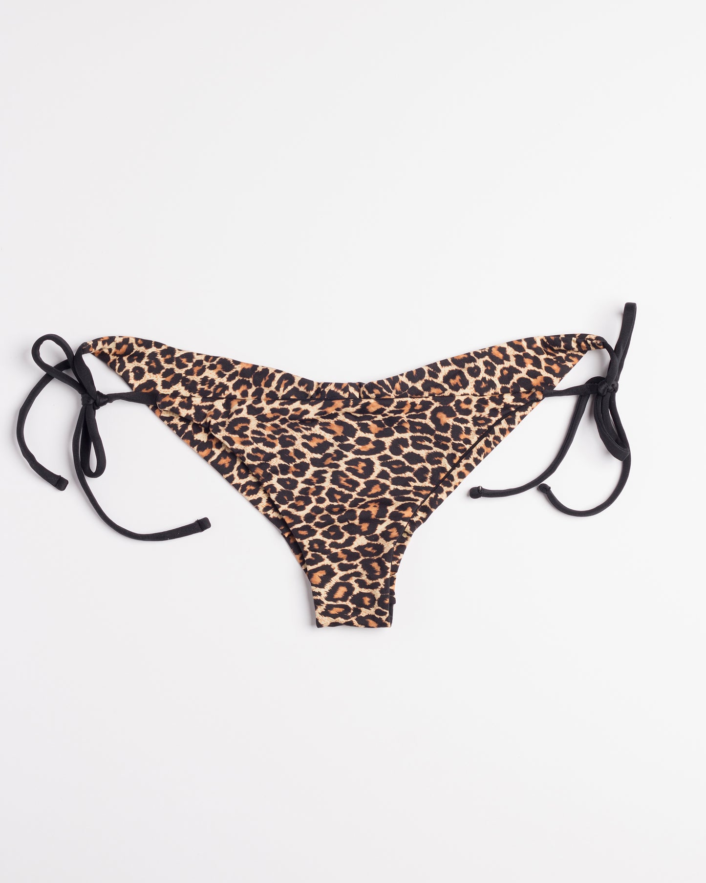 Leopárd mintás brazil bikini alsó, oldalsó megkötőkkel, fehér háttéren.