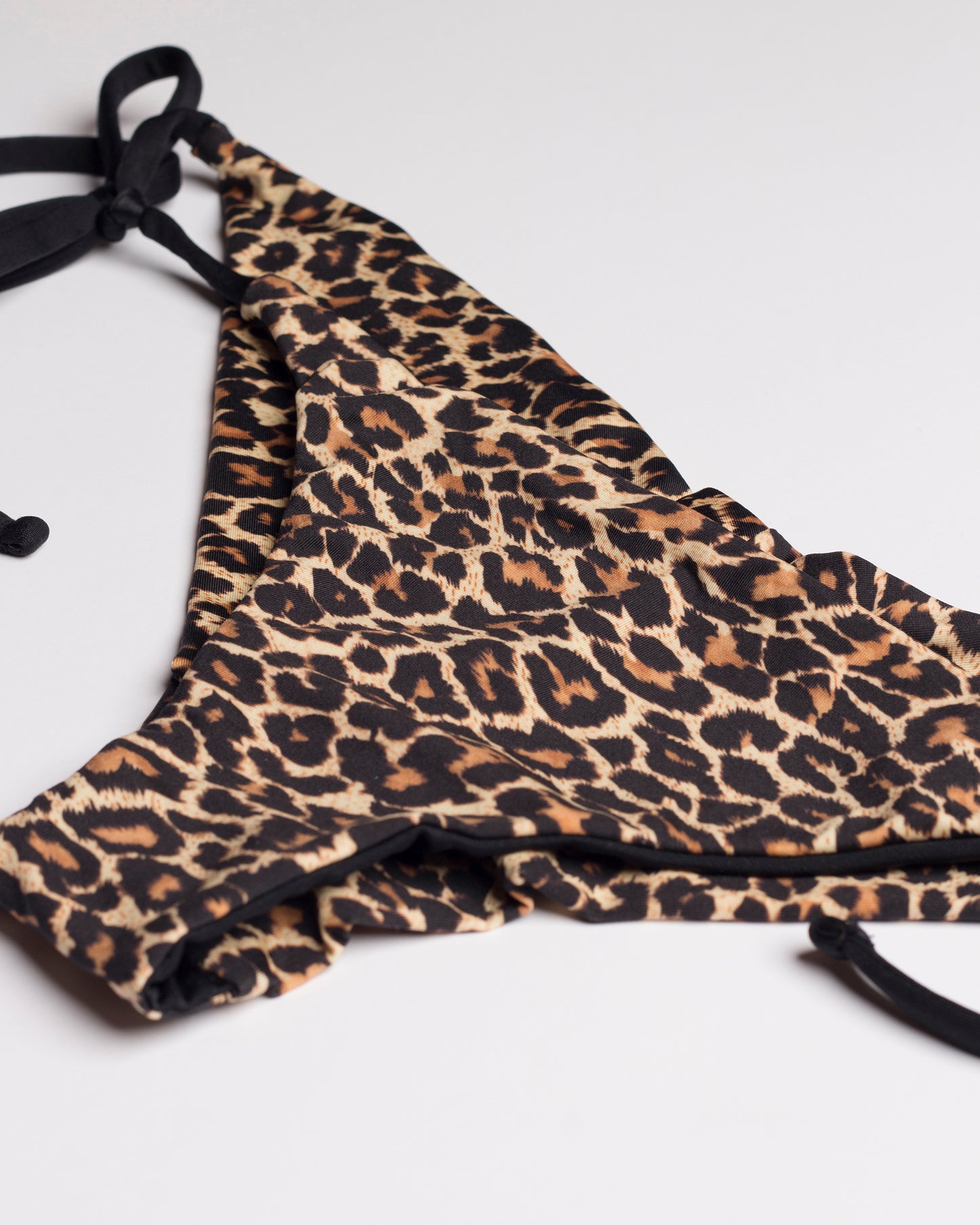 Leopárdmintás brazil bikini alsó oldalról és ferdén fotózva, fehér háttéren.