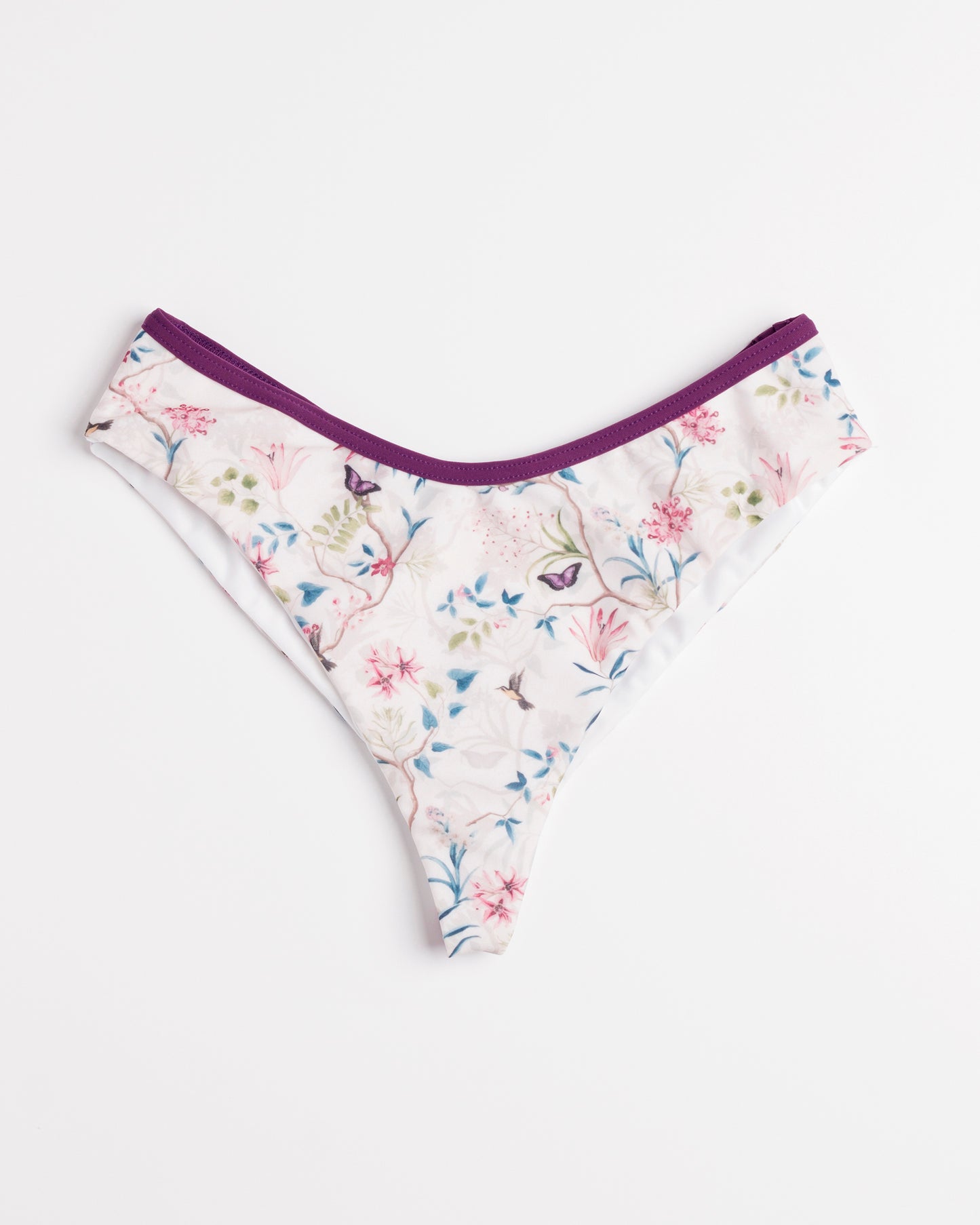 Romantikus virágos mintájú brazil fél-tanga fazonú bikini alsó, lila szegélyekkel, előről, fehér háttéren