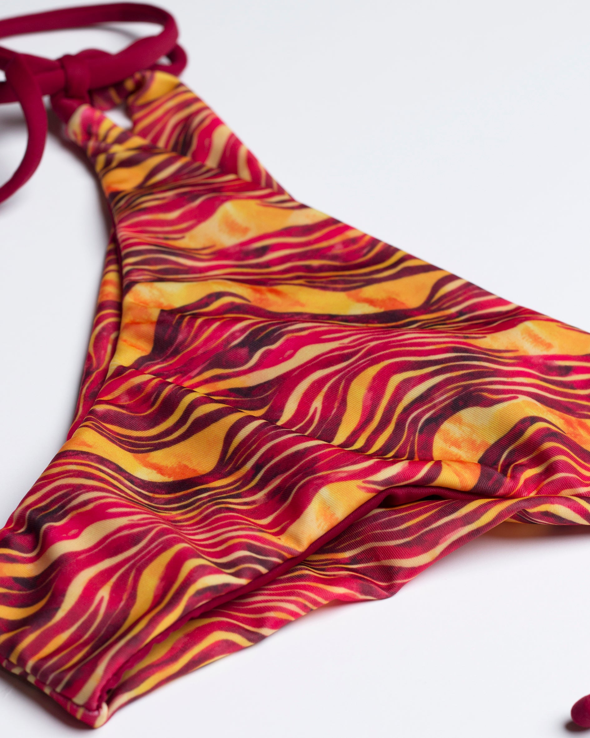 Szavanna mintás bordó megkötős brazil bikini alsó közeli képe a textil élénk színvilágáról