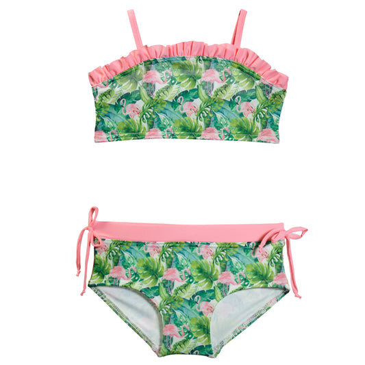 Rózsaszín flamingó és zöld trópusi levelek mintázatú kétrészes kislány bikini szett, kontrasztos rózsaszín fodros felsővel, vállpántokkal és oldalt megkötős alsóval, fehér alapon fotózva elöről.