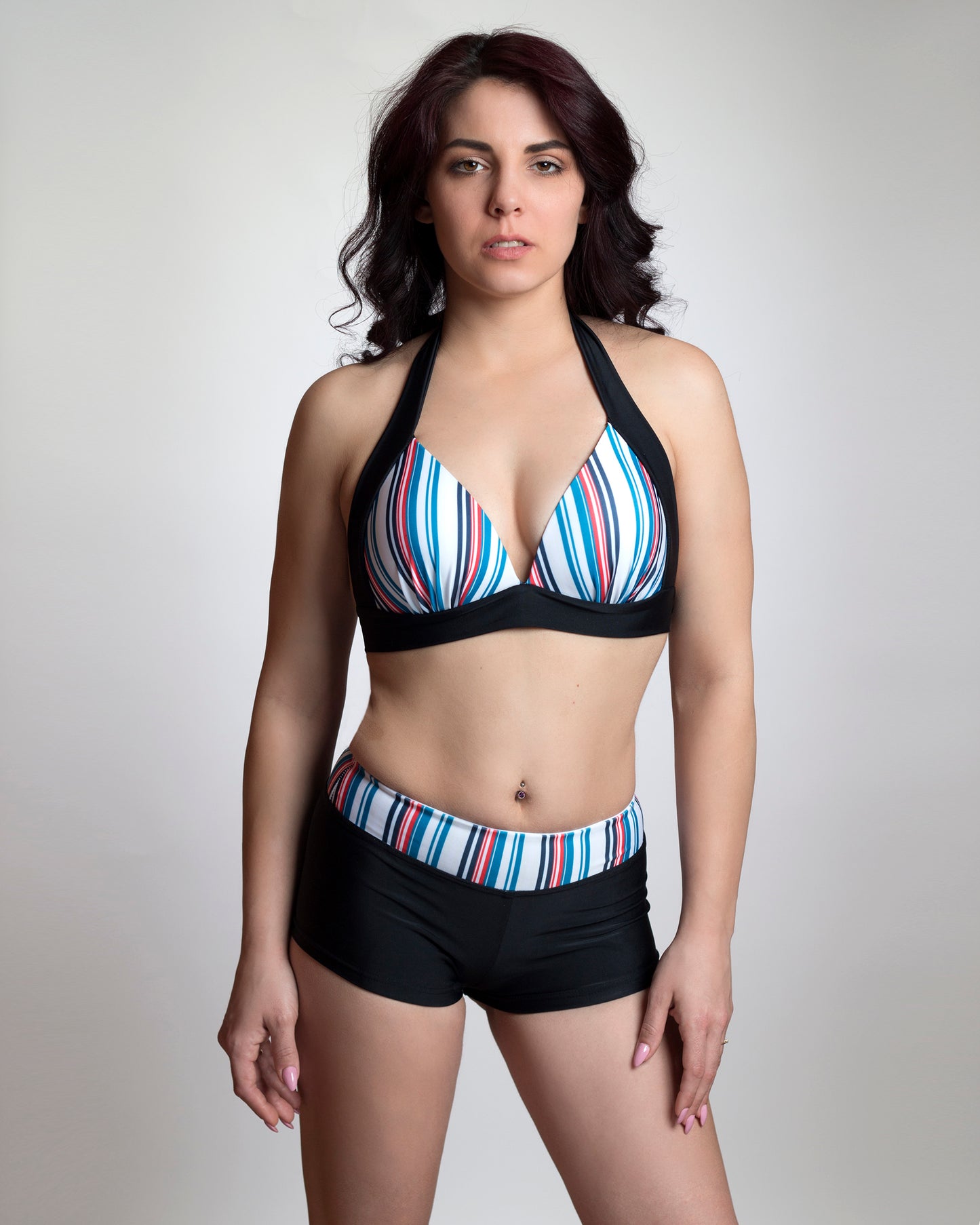 Kék csíkos háromszög push-up bikini felső széles fekete megkötőkkel és fekete rövid nadrág fazonú bikini alsó kék csíkos derékrésszel, előről, modellen
