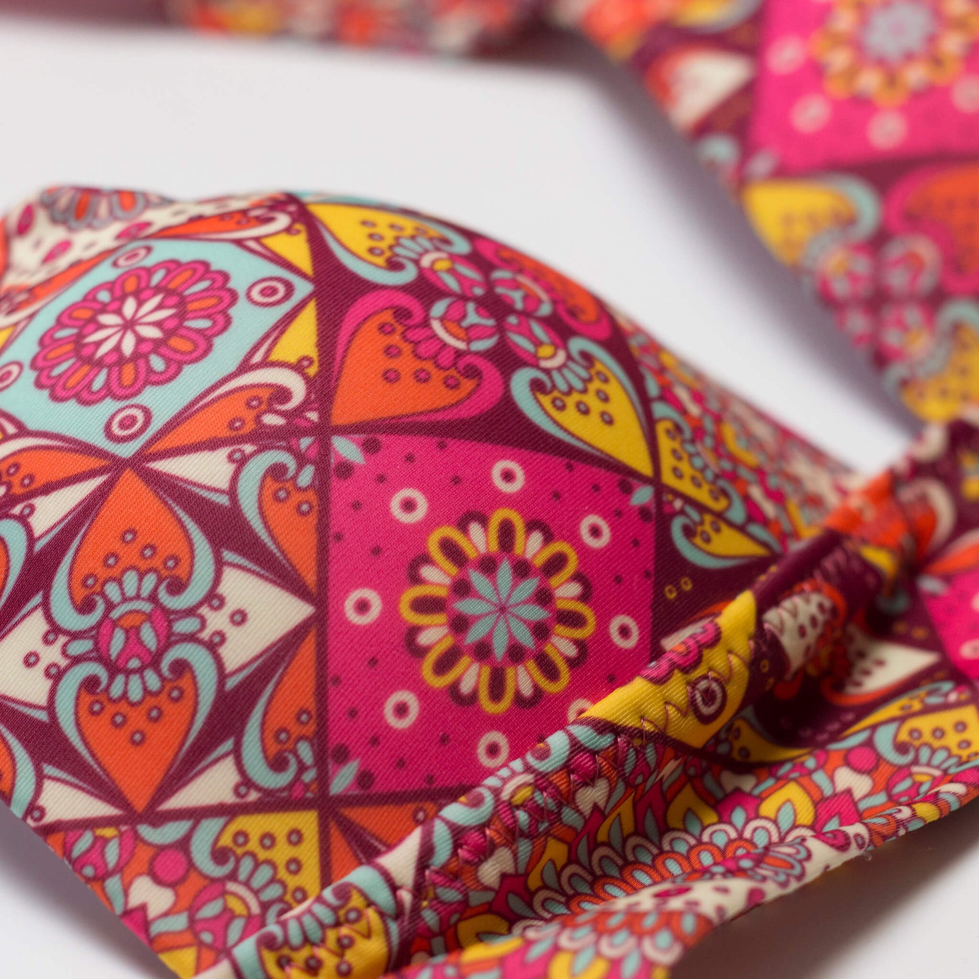 Mandala mintás női bikini felső kosara közelről, élénk színes részletek és finom varrások.