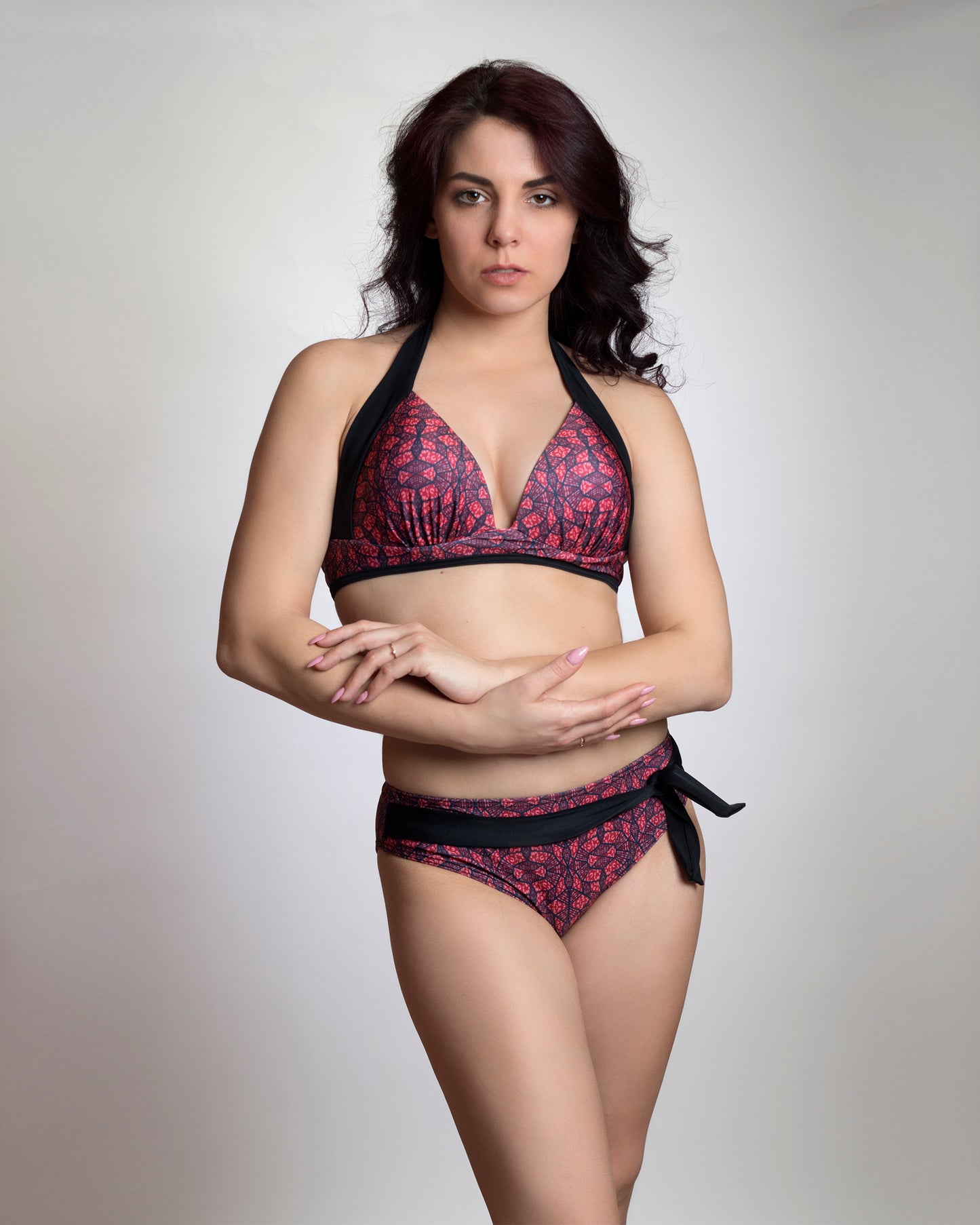 Vörös-fekete absztrakt mintás szélesített fekete pántos push-up bikini felső és díszmegkötős teli bikini alsó, modellen, előről